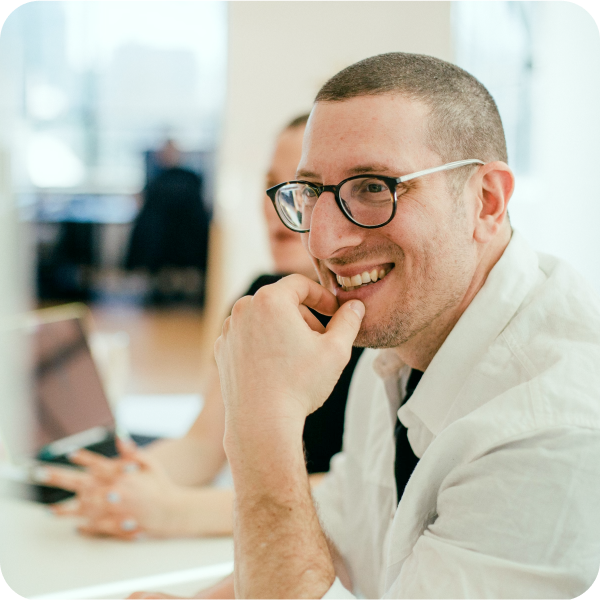 ITSM professional smiling at Service Desk, reflecting SysAid’s collaborative ITSM support environment. - SysAid