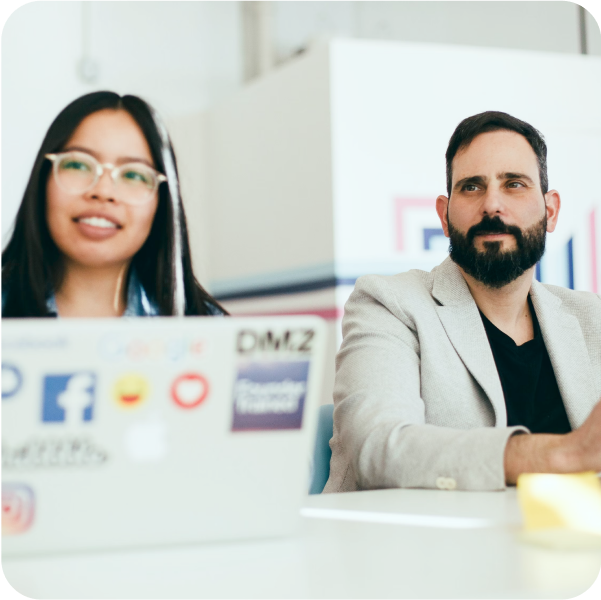 Two professionals discuss ITSM strategies at a modern office table, highlighting SysAid’s collaborative Service Desk approach. - SysAid
