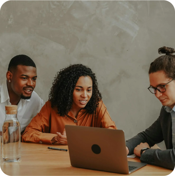 Three professionals discuss ITSM strategies at a table, reflecting SysAid’s collaborative approach to service management. - SysAid