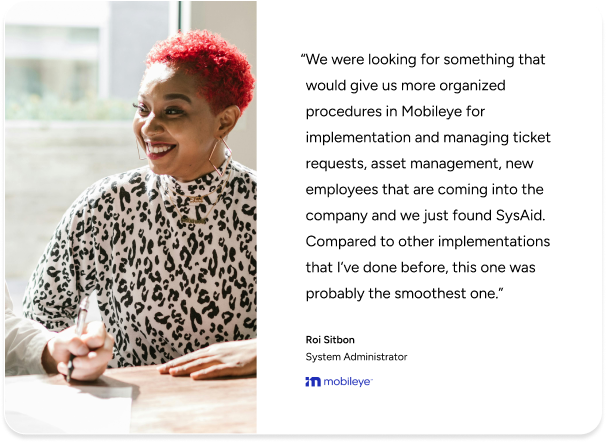 IT admin smiles at desk with pen, beside SysAid ITSM testimonial quote from Roi Sitbon of Mobileye. - SysAid