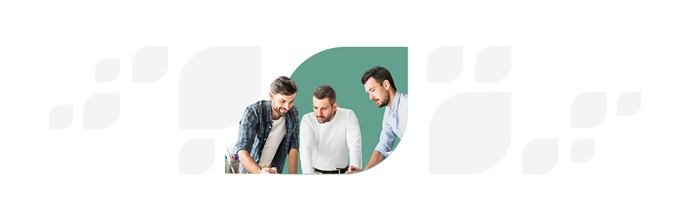 Three men, one in a plaid shirt, one in a white shirt, and one in a blue shirt, are leaning over and intently examining a document on a desk.