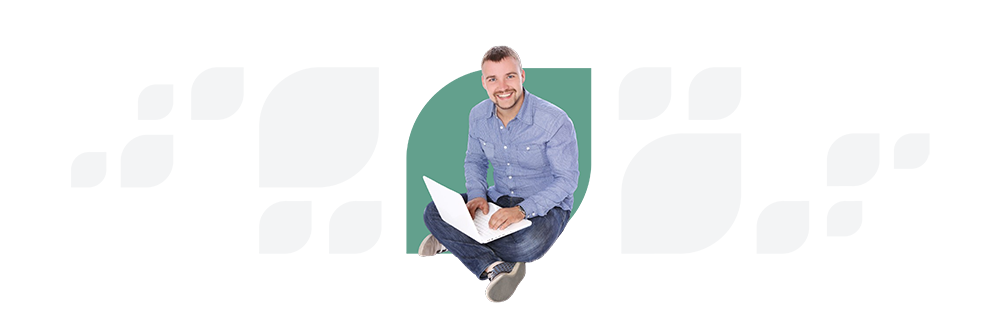 Man in a blue shirt sitting on a stool, smiling at the camera while holding a laptop and papers, against a white background with a green abstract shape.