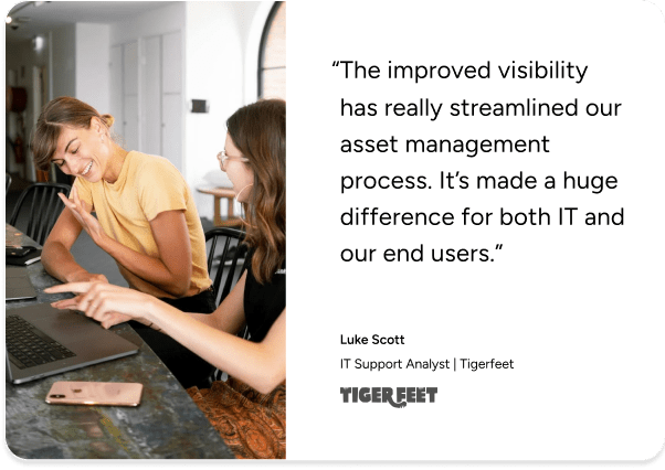 Two women at a table discuss work; SysAid ITAM testimonial highlights streamlined IT asset management. - SysAid
